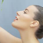 Profile view of a woman looking upward, showcasing smooth skin and natural beauty.