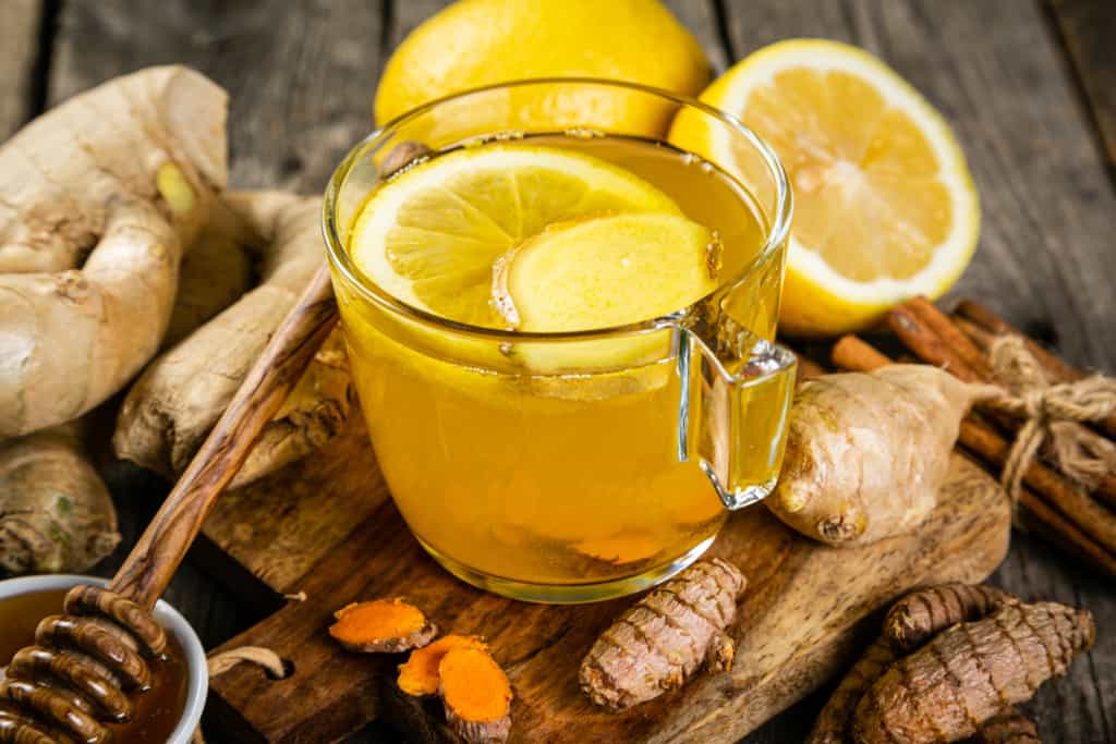 Fall immune system booster - ginger and turmeric tea and ingredients, rustic wood background