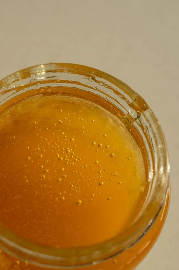 Close-up of golden raw honey in a jar