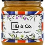 Jar of HoneyBee & Co. Heather Honey 280g with a deep amber colour and floral Union Jack label design.