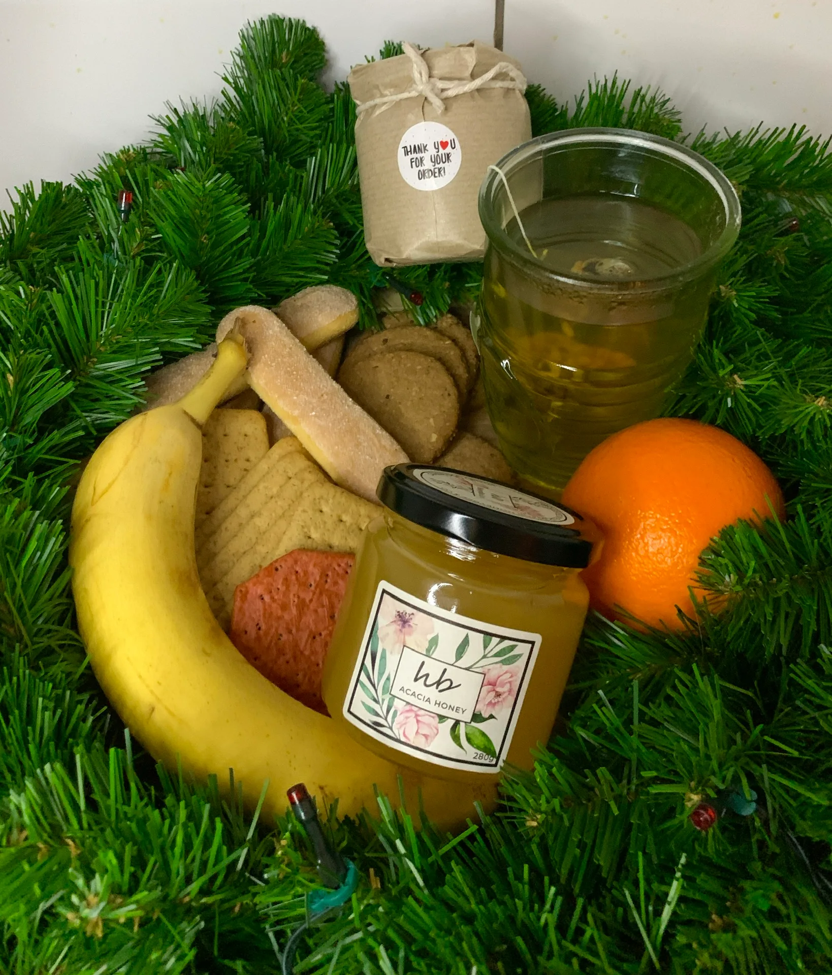 Basket of seasonal fruits alongside HoneyBee and Co. honey jars, representing honey as part of a varied natural diet