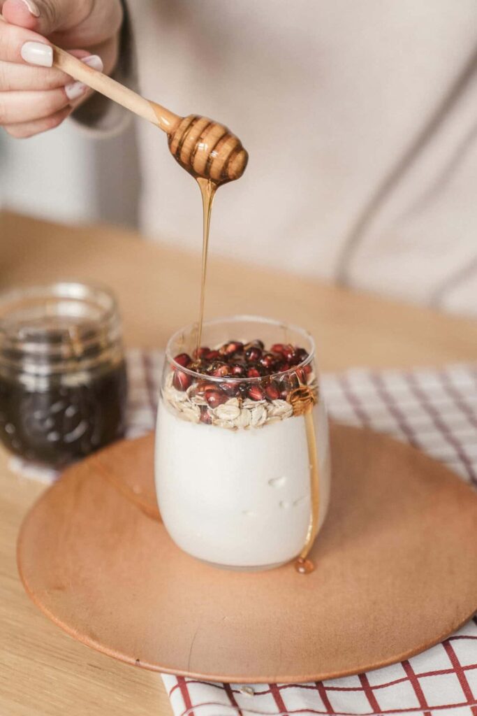 “Honey drizzling over yoghurt topped with granola and berries”