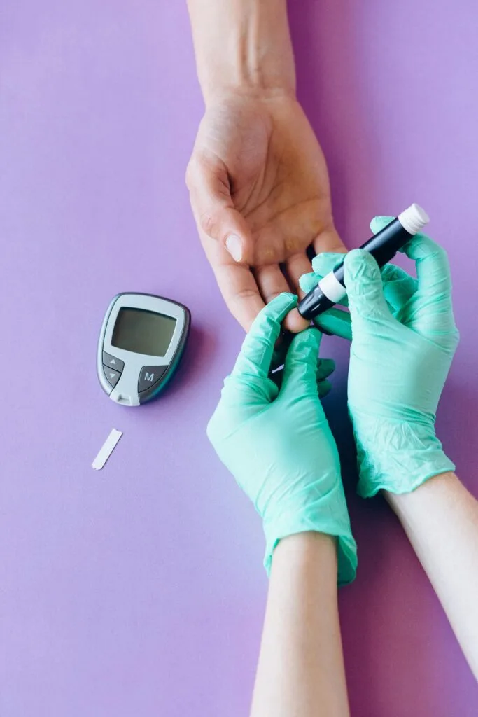 Healthcare worker checking blood sugar levels with a glucose meter