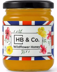 Vasetto di miele millefiori HoneyBee & Co. da 280 g, di colore ambrato e con etichetta floreale Union Jack.