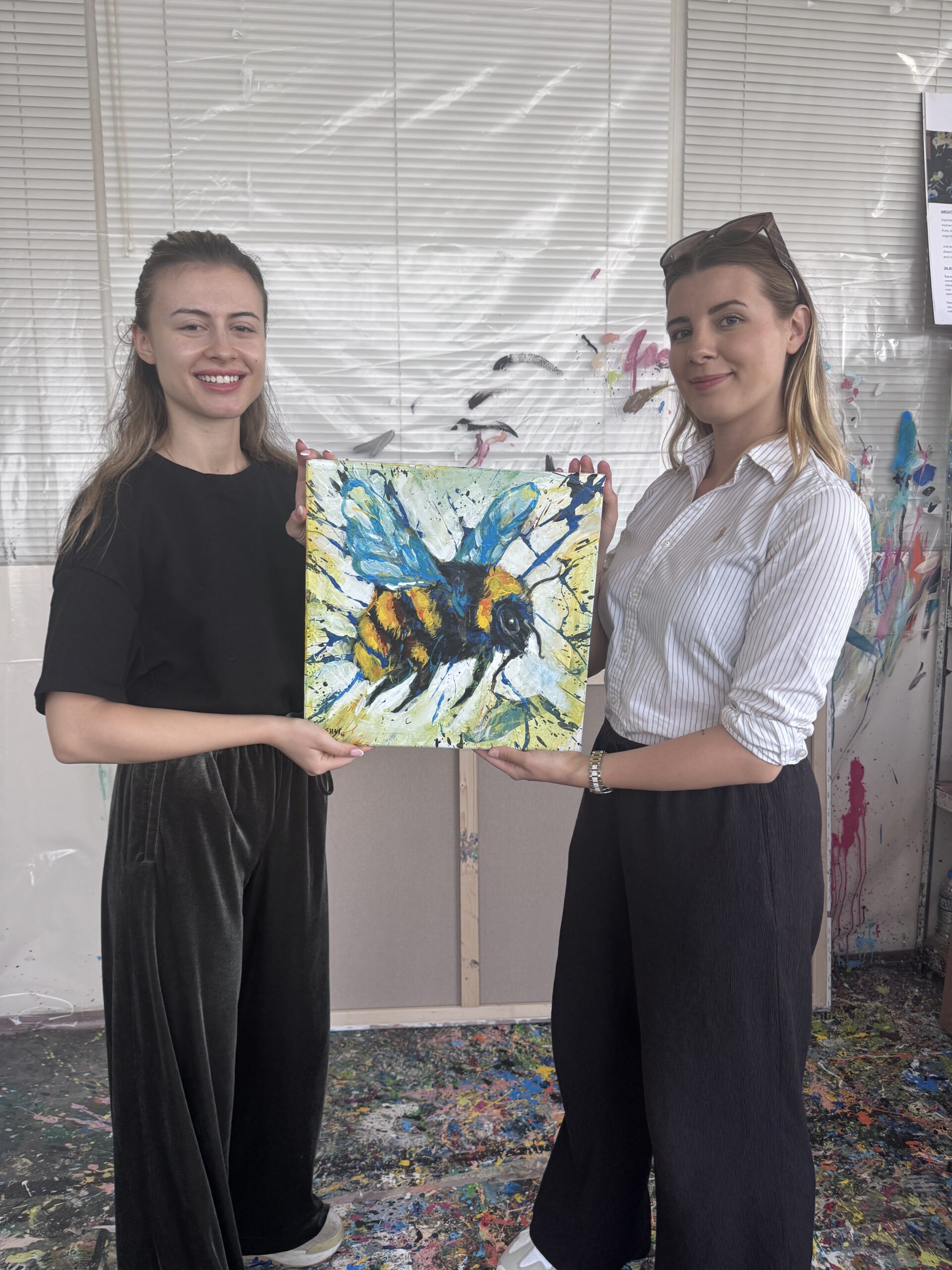 Visita allo studio con SILVI The Artist, che tiene in mano un dipinto raffigurante un calabrone
